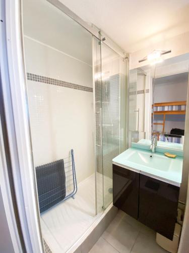 une salle de bain avec une douche en verre et un lavabo dans l'établissement Appartement T2 mezzanine vue mer avec piscine, à Saint-Cyprien