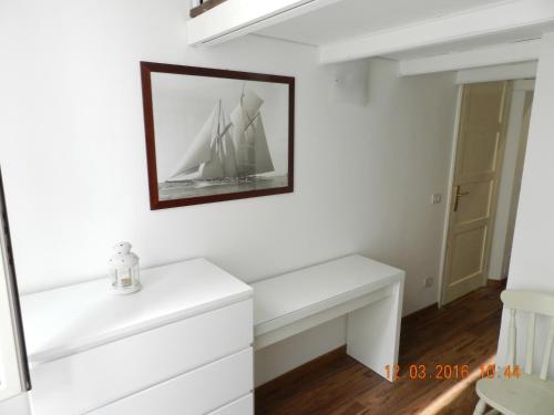 una habitación con un banco blanco con una foto en la pared en Casa di Anna - monolocale centrale en Reggio Calabria