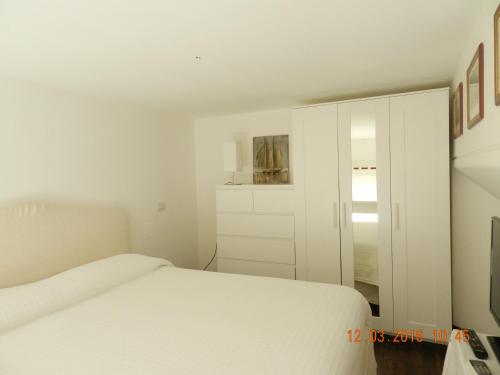 Habitación blanca con cama y espejo en Casa di Anna - monolocale centrale en Reggio Calabria