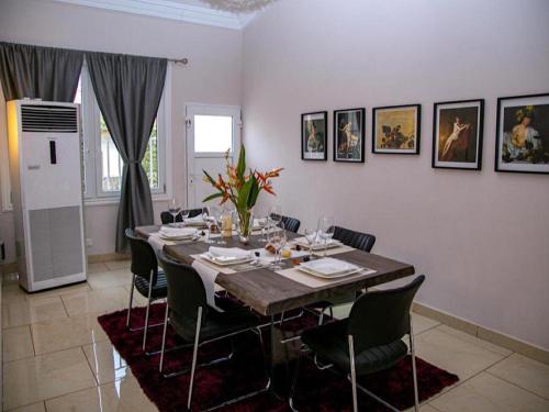 a dining room with a long table and chairs at Stunning 3-Bed House in Tema-Ahenfie Villa in Kwedonu
