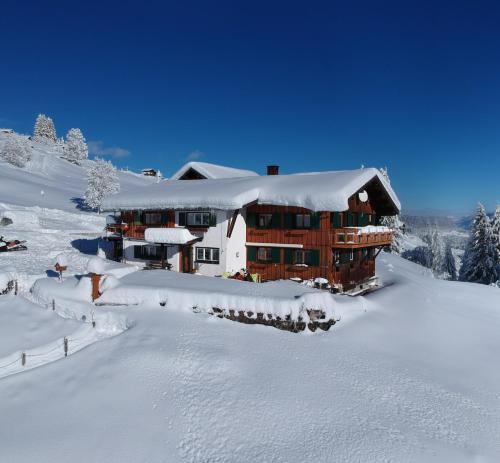 eine Lodge im Schnee mit Schnee in der Unterkunft bi dr Gondamaika in Hirschegg
