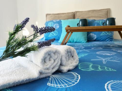 uma pilha de toalhas sentadas em cima de uma cama em Moradia Central Olhão - T2 PÁTIO AMPLO em Olhão