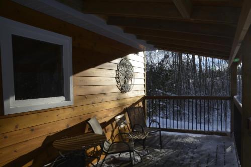 a screened in porch with two chairs and a television at Serene Westside Tiny Cabin in Clinton