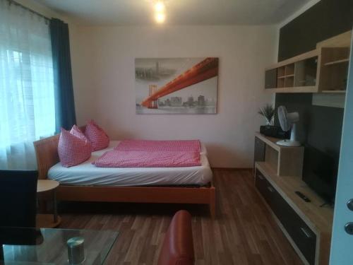 a small bedroom with a bed with pink sheets at Zentral gelegene, sehr ruhige und helle Wohnung in Graz