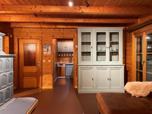 a kitchen with white cabinets in a wooden cabin at Haus Otis in Bad Mitterndorf