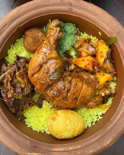a bowl of food with chicken and vegetables on rice at Settle Inn Tourist Lodge in Kandy