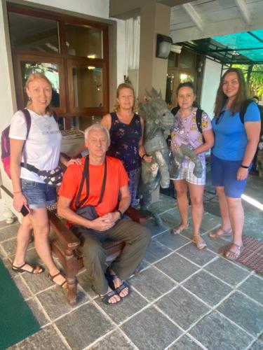 a group of people standing around a man sitting on a bench at Settle Inn Tourist Lodge in Kandy