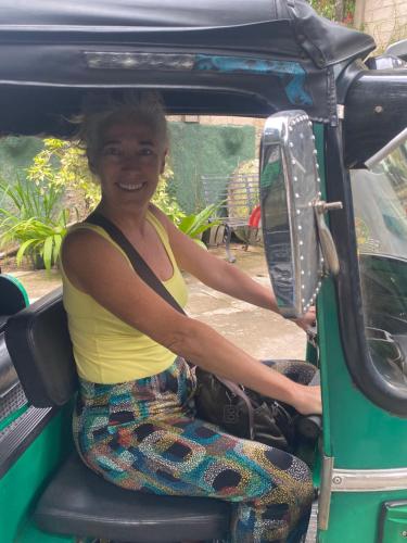a woman sitting in the back of a car at Settle Inn Tourist Lodge in Kandy