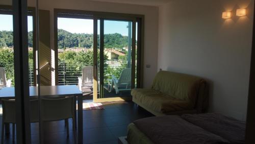 a room with a couch and a table and a balcony at INGRAPPA CUBE in Borso del Grappa