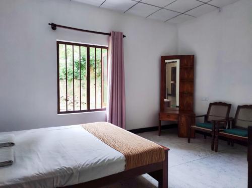 a bedroom with a bed and a window and a chair at Schatzi's Hideaway in Tangalle