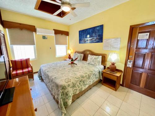 a bedroom with a bed and a ceiling fan at Belizian Reef Suites in San Pedro