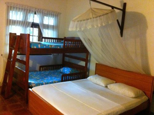 a bedroom with two bunk beds and a window at Little Paradise Tourist Guest House and Holiday Home in Anuradhapura