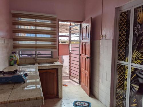 a kitchen with a sink and a counter top at Aryani Homestay in Kampong Kelemak