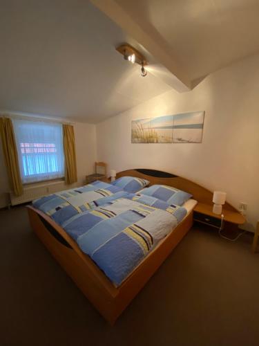 a bedroom with a bed with blue sheets and a window at Ferienwohnung Waschinski in Goslar