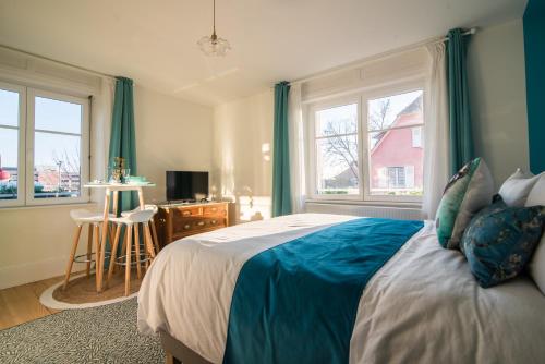 - une chambre avec un lit doté de draps bleus et de fenêtres dans l'établissement Maison 1934 - Colmar Gare & Parking gratuit, à Colmar