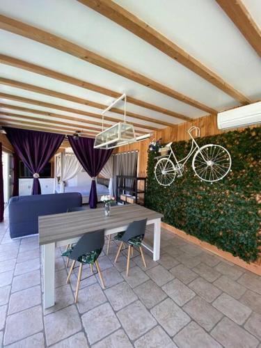 a dining room with a table and a bike on a wall at Koh Samui Siam Manahakhon Appart & Spa in Rieux-de-Pelleport