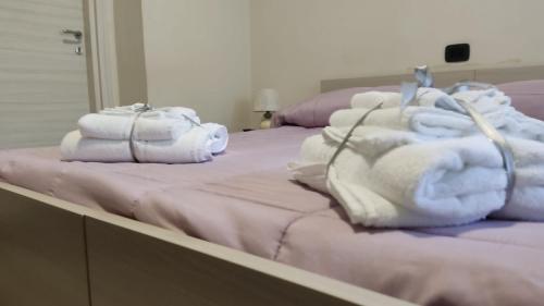 two beds with towels on them in a room at Civico 83 in Reggio Calabria