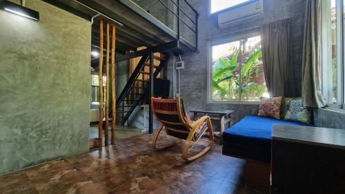 a room with a couch and a chair and a window at Aonang Third Place Hometel in Ao Nang Beach