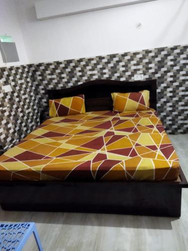 a bedroom with a bed with a yellow and brown at Budget Hotel in Patna