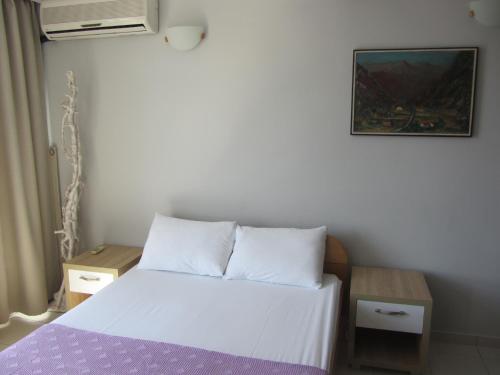 a small bedroom with a bed and a picture on the wall at Cernogoriya voyage in Rafailovici
