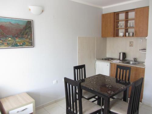 a kitchen with a table and chairs in a room at Cernogoriya voyage in Rafailovici