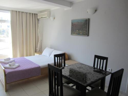 a bedroom with a table and a bed and a table and chairs at Cernogoriya voyage in Rafailovici
