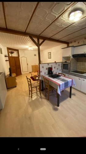 une cuisine avec une table et des chaises dans une pièce dans l'établissement Les Geraniums, à Colligny