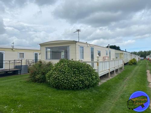 un mobile home sur le côté d'une cour dans l'établissement Chapel St Leonards Caravan, à Chapel St. Leonards