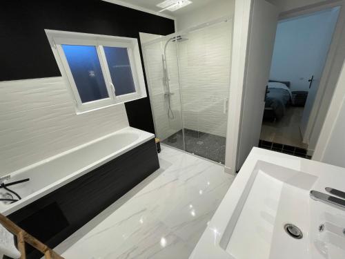 a bathroom with a tub and a sink and a shower at Gîte le belloy'Zo in Belloy sur Somme