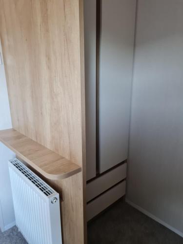 a small room with a wooden wall and a radiator at Caravan on Fantastic site in Dunbar