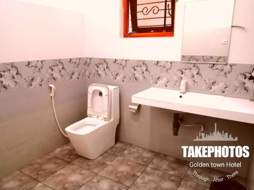 a bathroom with a toilet and a sink at Golden Town Hotel in Tangalle