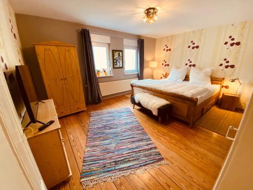 a bedroom with a bed and a rug at Gemütliche Landhaus Wohnung auf dem Ponyhof - Himmelbett, Kamin & Garten in Ortenberg