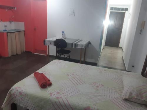 a bedroom with a bed with a red object on it at Pousada do Luquinhas in Brasilia