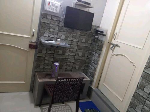 a room with a small table and a tv on a wall at Budget Hotel in Patna