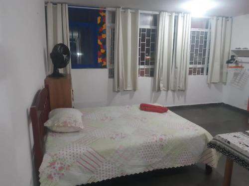a bedroom with a bed with a white comforter at Pousada do Luquinhas in Brasilia