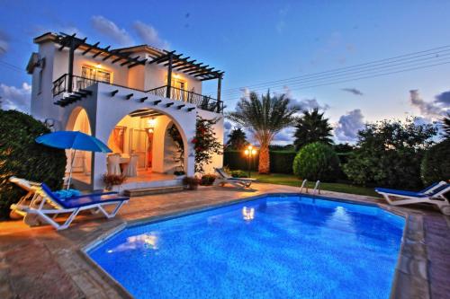 a villa with a swimming pool in front of a house at Lemon Grove Villa Ena in Argaka