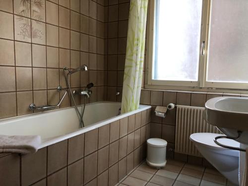 ein Badezimmer mit einer Badewanne, einem WC und einem Waschbecken in der Unterkunft Hotel Gebidem in Visperterminen