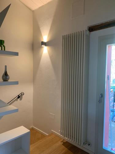 a room with a vertical radiator and a window at La casetta rossa in Rimini