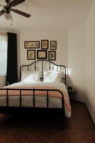 a bedroom with a bed with white pillows and a ceiling at Authentieke vakantiewoning op 200 m van het strand in De Panne