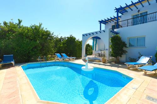 a swimming pool in front of a villa at Lemon Grove Villa Dio in Argaka
