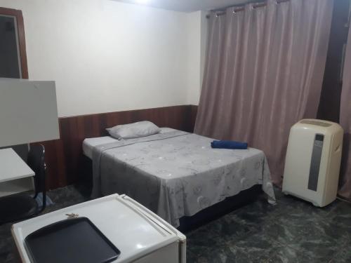 a small room with a bed and a tv at Pousada do Luquinhas in Brasilia