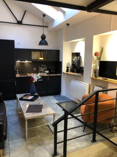 a living room with a table and a kitchen at jaccuzi & spa des caves Stanislas in Nancy