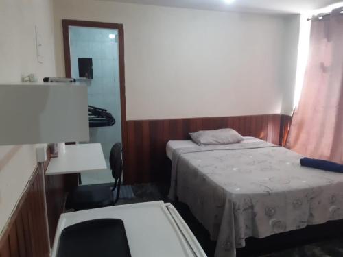 a small room with two beds and a mirror at Pousada do Luquinhas in Brasilia