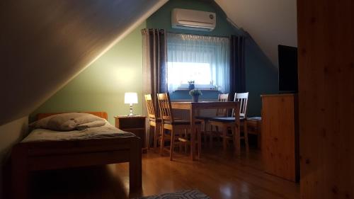 a bedroom with a bed and a dining room table at Willa Orle Gniazdo in Biały Kościół