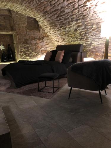 a living room with a couch and a chair at jaccuzi & spa des caves Stanislas in Nancy
