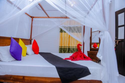 1 dormitorio con 1 cama con almohadas coloridas en Sajana Ocean Hill, en Mirissa