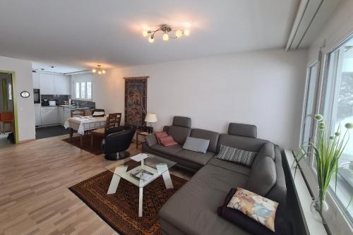uma sala de estar com um sofá e uma mesa em Apartmenthaus Gauenpark - CharmingStay em Flumserberg