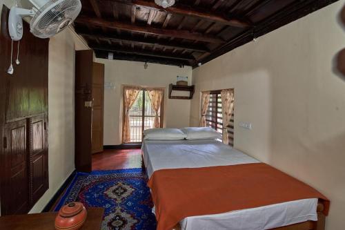 1 Schlafzimmer mit 2 Betten und einem blauen Teppich in der Unterkunft The Mana-Heritage stay - Chengazhimattam Mana in Kottayam