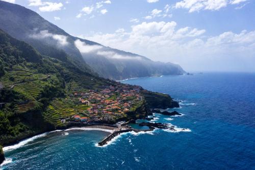 an aerial view of a town on the side of a mountain at Madeira Black Sand House by Stay Madeira Island in Seixal