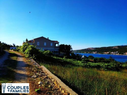 een huis op een heuvel naast het water bij Villa Vila in Novalja